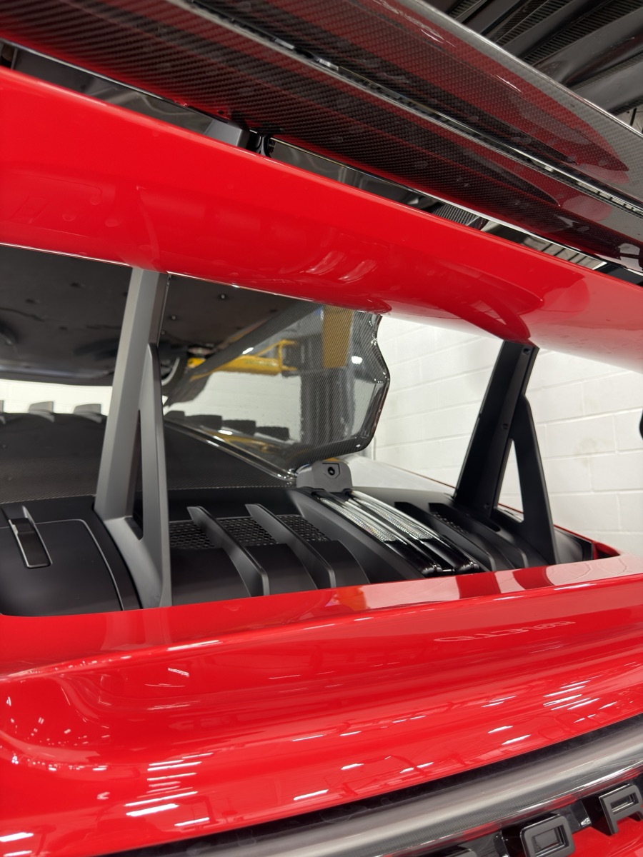 Side profile under the rear wing. The housing follows the deck lid's compound curves.