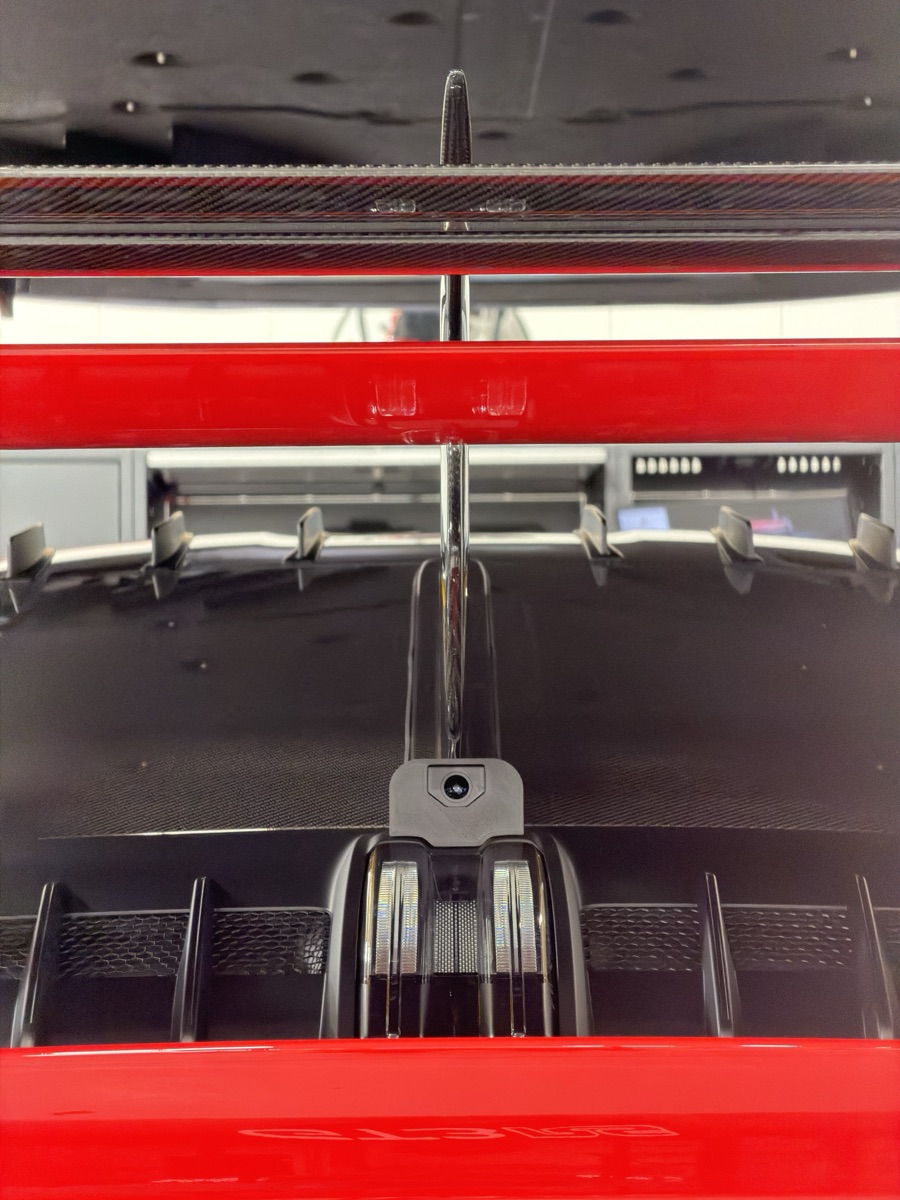 Installed on the car's centreline beneath the Manthey fin — clean rearward view and clean cable routing.